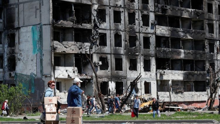 Des civils devant des immeubles détruits de Marioupol, le 29 avril.