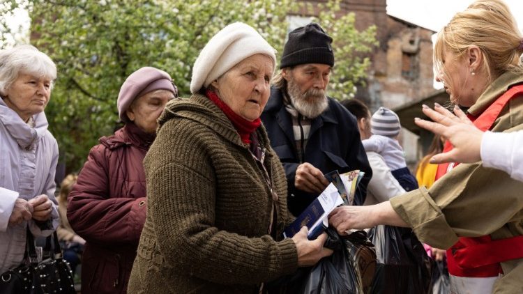 Desplazados internos evacuados del este del país hacen fila para recibir donaciones de alimentos en la iglesia católica de San José, en medio de la invasión rusa en Ucrania, en Dnipro