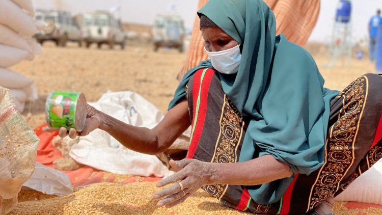 Eine Frau in Äthiopien sammelt Getreide auf