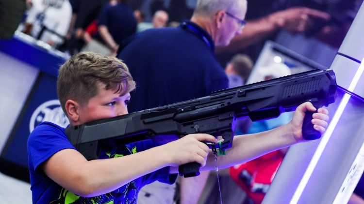 Um menino experimenta uma espingarda Smith and Wesson calibre 12 enquanto as pessoas participam da convenção anual da National Rifle Association (NRA) em Houston, Texas, EUA, em 28 de maio de 2022. REUTERS/Shannon Stapleton
