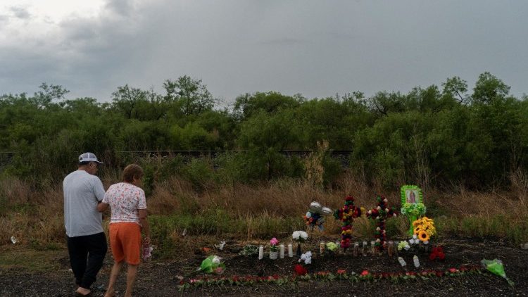 Local residents pay a visit to mourn the victims at the scene where dozens of migrants were found dead inside a trailer, San Antonio, Texas