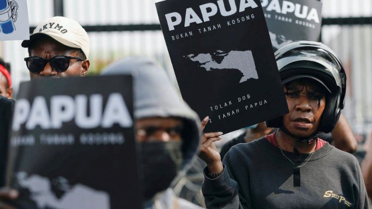 Demonstranten halten Schilder und protestieren vor dem indonesischen Parlament, nachdem die Gesetzgeber einen Gesetzentwurf zur Schaffung von drei neuen Provinzen in der unterentwickelten Region Papua in Jakarta verabschiedet haben.