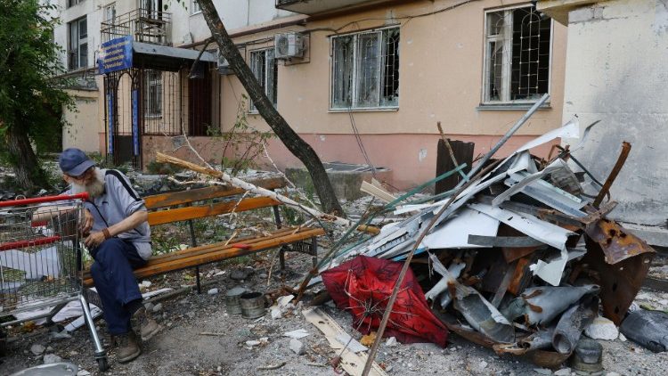 Um morador local senta-se em um banco perto de um prédio de apartamentos danificado durante o conflito Ucrânia-Rússia na cidade de Sievierodonetsk, na região de Luhansk, Ucrânia, 1º de julho de 2022 REUTERS/Alexander Ermochenko