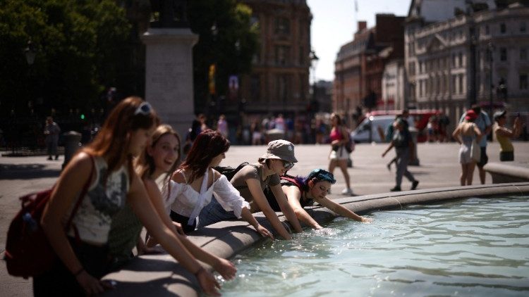 People cool off in a water fountain during a heatwave, at Trafalgar Square in London