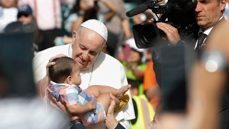 Papst Franziskus segnet ein Baby bei seiner Ankunft im Stadion 