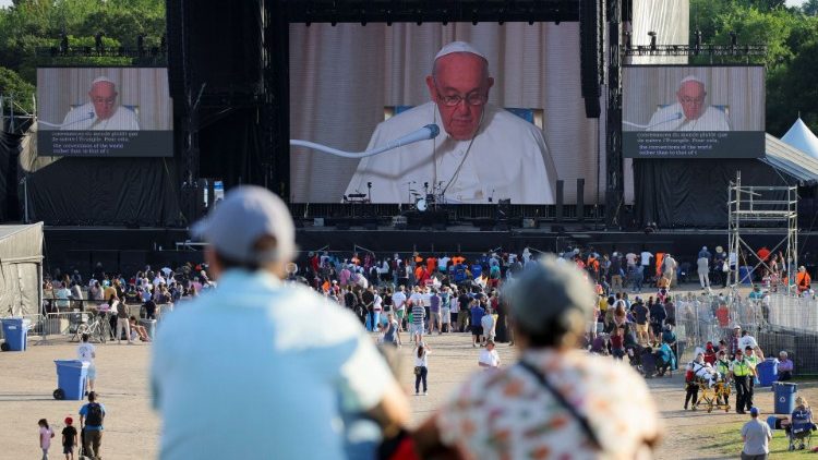 Algunas personas siguen la visita del Papa en las pantallas gigantes durante el Encuentro con autoridades civiles, representantes de los pueblos indígenas y miembros del cuerpo diplomático en la Citadelle de la ciudad de Quebec, Canadá, el 27 de julio de 2022.