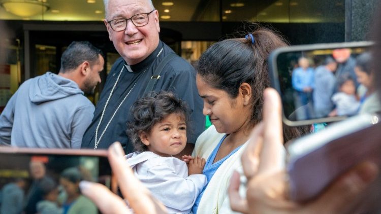 Cardinal Timothy Dolan greets migrant families outside of Catholic Charities of New York