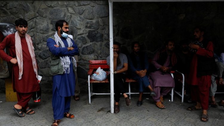 Families of victims of Wednesday's explosion wait in front of an emergency hospital in Kabul