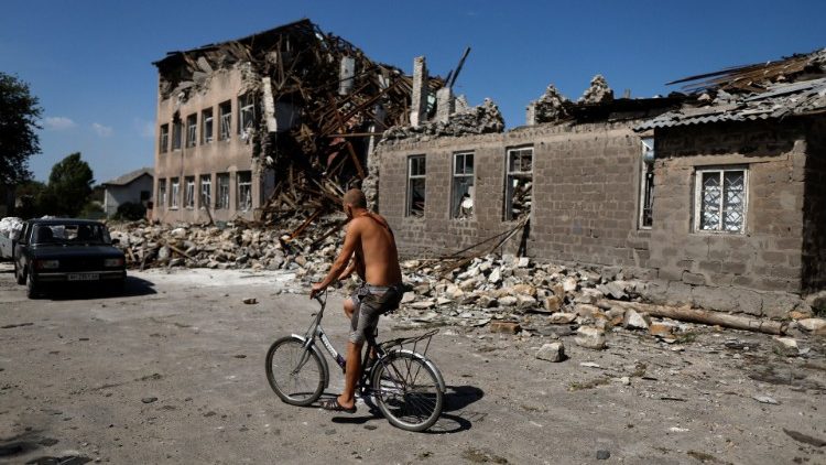 Um homem anda de bicicleta perto de uma escola destruída, enquanto o ataque da Rússia na Ucrânia continua, em Toretsk, região de Donetsk, Ucrânia 22 de agosto de 2022. REUTERS/Ammar Awad