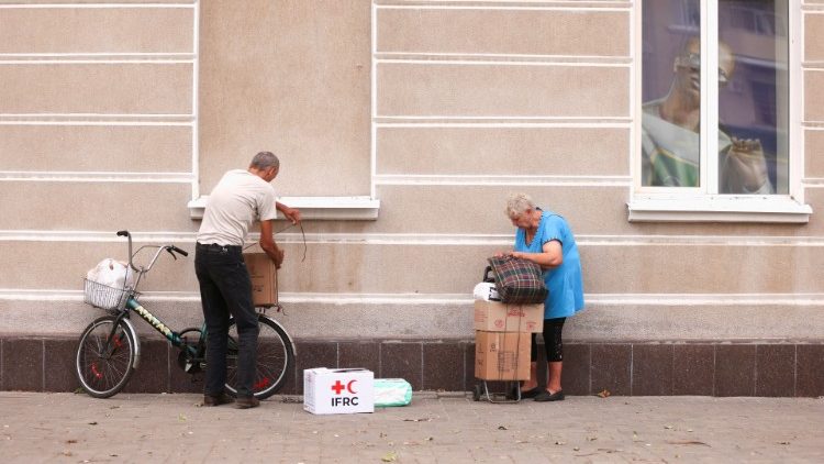 Pessoas pegam caixas com comida depois de recebê-las durante distribuição de ajuda humanitária, durante a evacuação de áreas afetadas pela guerra no leste da Ucrânia, enquanto o ataque da Rússia à Ucrânia continua, em Bakhmut, Ucrânia 26 de agosto de 2022. REUTERS/Ammar Awad