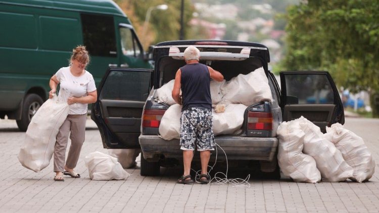 Pessoas recebem pão durante distribuição de ajuda humanitária, durante a evacuação de áreas afetadas pela guerra no leste da Ucrânia, enquanto o ataque da Rússia à Ucrânia continua, em Bakhmut, Ucrânia 26 de agosto de 2022. REUTERS/Ammar Awad