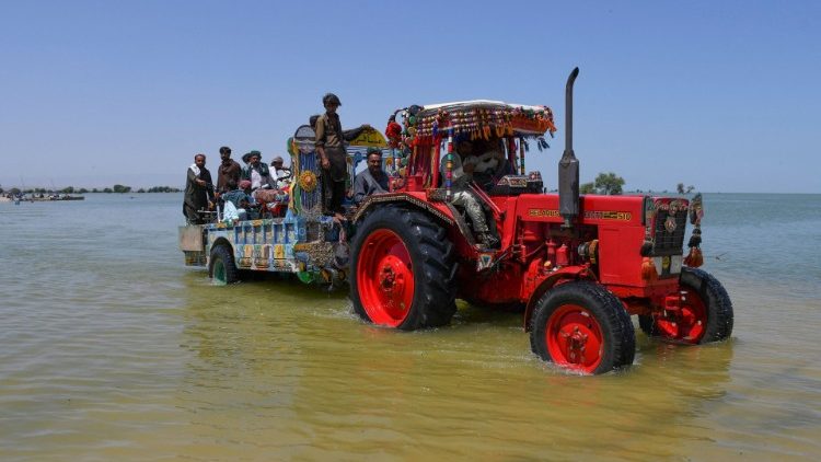 Aldeões embarcam em um carrinho de trator enquanto viajam em meio a enchentes, após chuvas e inundações durante a estação das monções na vila de Bajara, Sehwan, Paquistão, 31 de agosto de 2022. REUTERS/Yasir Rajput