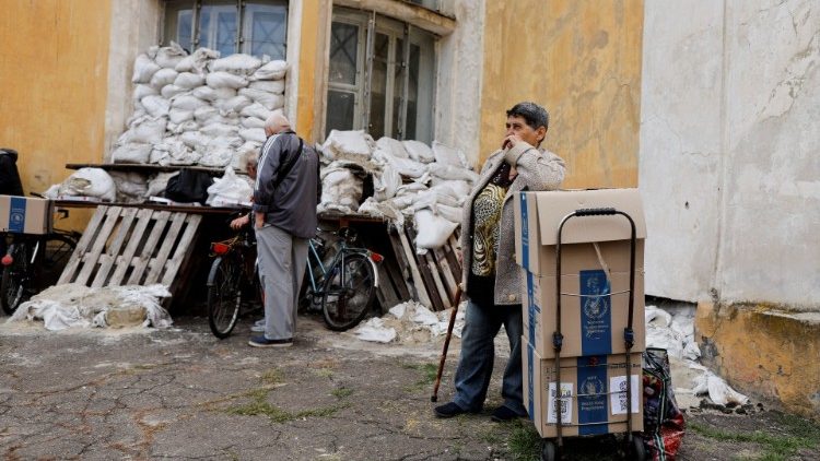 Mulher ao lado de caixas enquanto pessoas recebem ajuda humanitária organizada pelo município e pelo Programa Mundial de Alimentos, em meio à invasão da Rússia, em Kramatorsk, região de Donetsk, Ucrânia, 6 de setembro de 2022. REUTERS/Ammar Awad