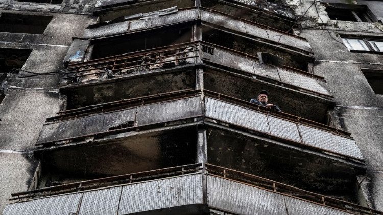 Um morador local olha da varanda de um prédio residencial destruído por ataques militares em um mercado de rua, enquanto a invasão russa da Ucrânia continua, em Saltivka, uma das áreas residenciais mais danificadas de Kharkiv, Ucrânia 6 de setembro de 2022. REUTERS/Viacheslav Ratynskyi
