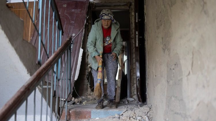 Uma mulher limpa a entrada de um prédio residencial destruído por um ataque, em meio à invasão russa da Ucrânia, em Mykolaiv, Ucrânia, 11 de setembro de 2022 REUTERS/Umit Bektas