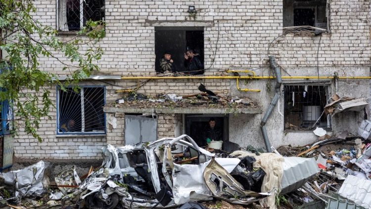 Homens fumam enquanto outros limpam os escombros de um prédio residencial destruído por um ataque, em meio à invasão russa da Ucrânia, em Mykolaiv, Ucrânia, 11 de setembro de 2022. REUTERS/Umit Bektas