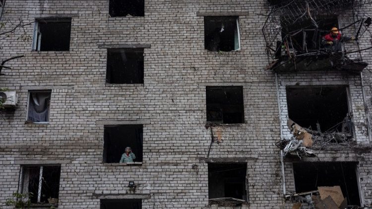 Uma mulher fala ao telefone enquanto um oficial de resgate trabalha em um prédio residencial destruído por um ataque, em meio à invasão russa da Ucrânia, em Mykolaiv, Ucrânia, 11 de setembro de 2022. REUTERS/Umit Bektas