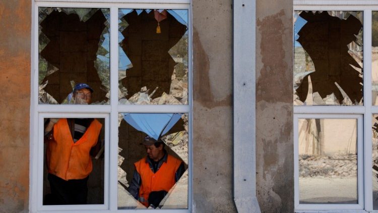 Homens removem cacos de vidro de janelas quebradas de um prédio danificado por bombardeios recentes durante o conflito Rússia-Ucrânia na cidade de Kadiivka (Stakhanov) na região de Luhansk, Ucrânia 19 de setembro de 2022 REUTERS/Alexander Ermochenko