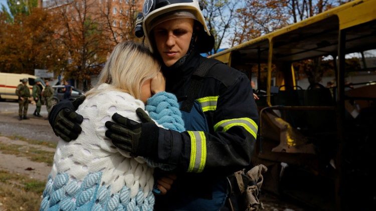 Un bombero consuela a una mujer junto al autobús destruido por un bombardeo en el que murió su hija en Donetsk, Ucrania 22 de septiembre de 2022. 