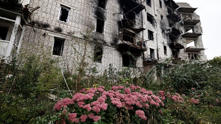 Flowers grow near a destroyed building in Izium, Ukraine