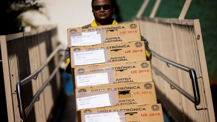 An employee carries electronic voting machines in Brasilia