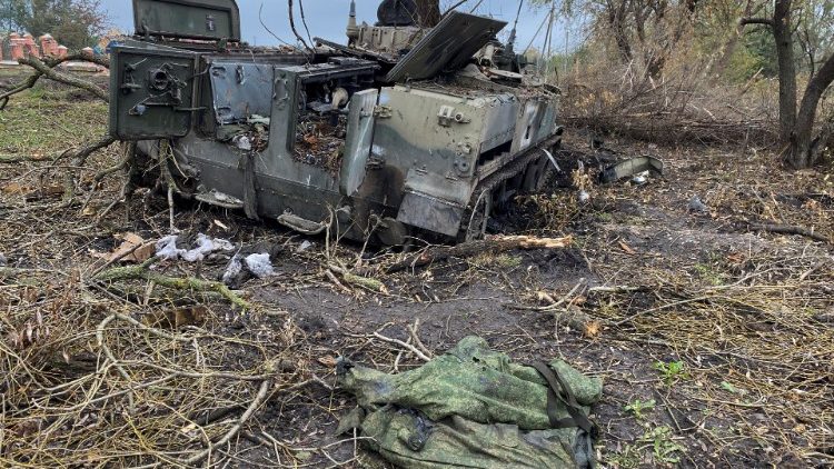 Military uniform lays next to an abandoned Russian infantry fighting vehicle BMD-4 in the village of Kurylivka