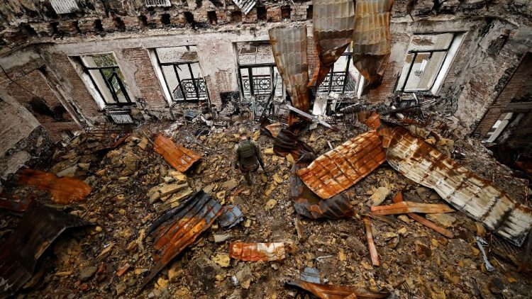Ein Beamter untersucht eine durch russischen Beschuss zerstörte Schule in Lyman (Donetsk)