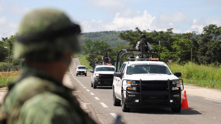 Members of the military and National Guard stand at a military checkpoint, in El Zapote, Mexico.