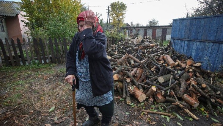 Uma idosa reage ao lado de lenha entregue pela administração local para aquecer sua casa, enquanto o ataque da Rússia à Ucrânia continua, na vila de Derhachi, região de Kharkiv, Ucrânia 20 de outubro de 2022. REUTERS/Vyacheslav Madiyevskyy