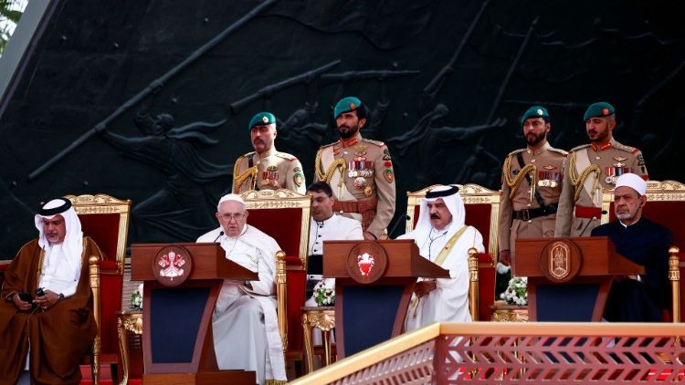 Ferenc pápa beszél a párbeszéd fórum lezárásán, mellette a király, a trónökökös és jobbról az Al-Azhar főimámja    