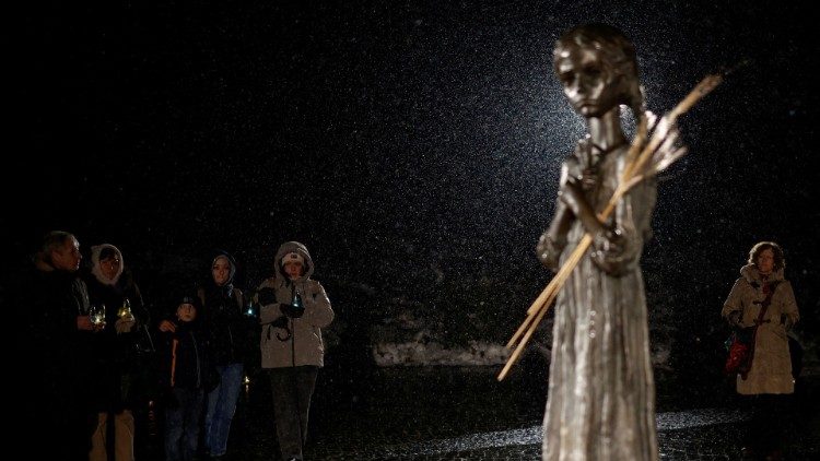 Pessoas seguram velas ao lado de um monumento às vítimas do Holodomor durante uma cerimônia de comemoração da fome de 1932-33, na qual milhões morreram de fome, em meio ao ataque da Rússia à Ucrânia, em Kyiv, Ucrânia, 26 de novembro de 2022 REUTERS/Valentyn Ogirenko