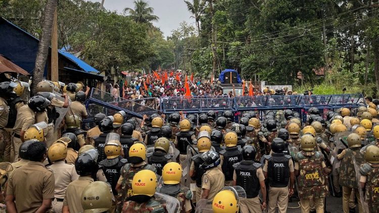 Polizeibeamte stehen während einer Protestkundgebung der Befürworter des geplanten Hafenprojekts in Vizhinjam an den Barrikaden Wache