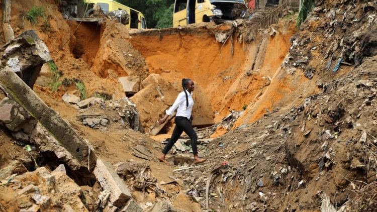 Eine Frau geht durch eine schwer beschädigte Straße, nachdem heftige Regenfälle Überschwemmungen und Erdrutsche verursacht haben, am Stadtrand von Kinshasa