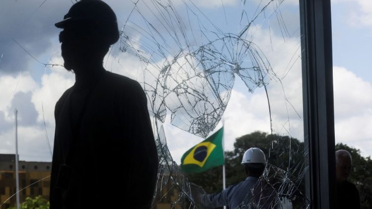 Workers repair damaged windows following Sunday's anti-democratic riots