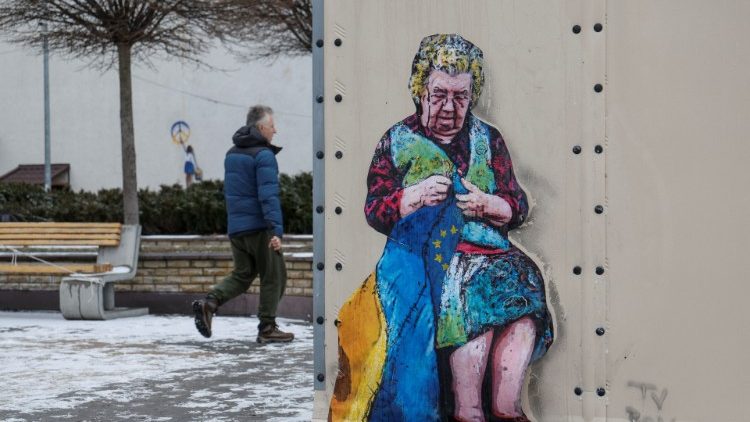 Um homem caminha perto de uma obra de arte do famoso artista de rua Tvboy, criada na parede de um 'centro de invencibilidade', em meio ao ataque da Rússia à Ucrânia, na cidade de Bucha, nos arredores de Kyiv, Ucrânia, 29 de janeiro de 2023 REUTERS/Valentyn Ogirenko