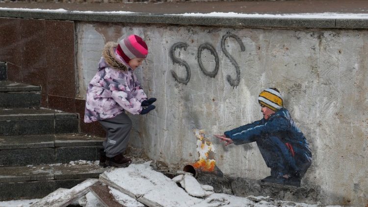 Anastasia, 4 Jahre, steht neben einem Kunstwerk des berhmten Stra?enknstlers Tvboy in Butscha