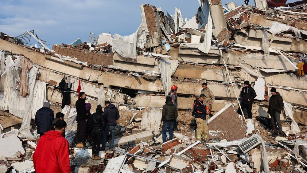 Pessoas observam a destrui??o enquanto equipes de resgate procuram sobreviventes nos escombros aps um terremoto em Hatay, Turquia, 7 de fevereiro de 2023 REUTERS/Umit Bektas