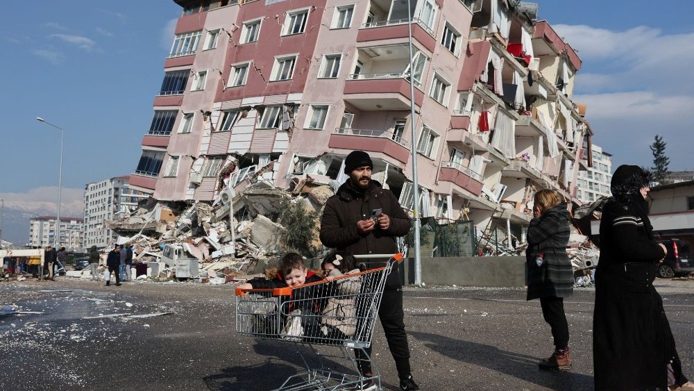 Crian?as em um carrinho de compras perto de um prdio que desabou aps um terremoto em Hatay, Turquia, 7 de fevereiro de 2023 REUTERS/Umit Be