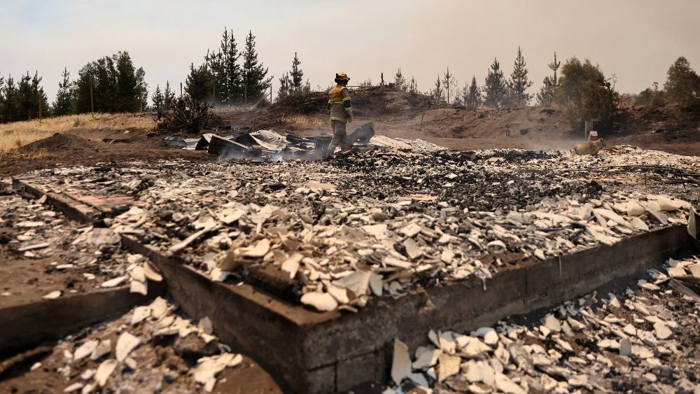 Um bombeiro caminha sobre os restos de uma casa aps um incndio florestal, em Rio Claro, Chile, 7 de fevereiro de 2023. REUTERS/Ivan Alvarado