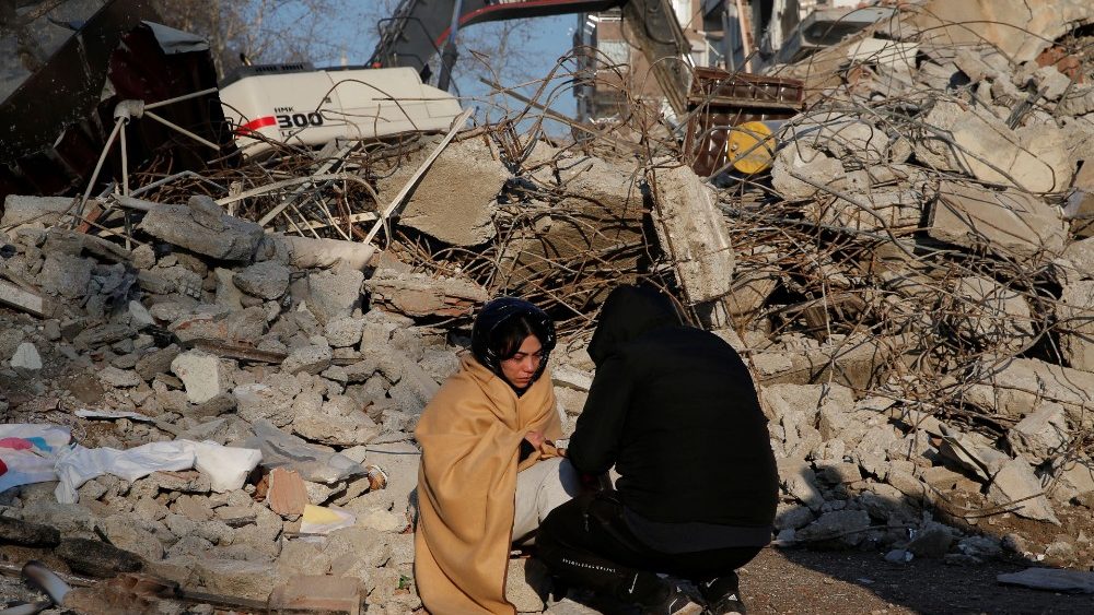 Pessoas desoladas ao lado de um prdio que desabou aps um terremoto em Kahramanmaras, Turquia, 8 de fevereiro de 2023. REUTERS/Dilara Senkaya