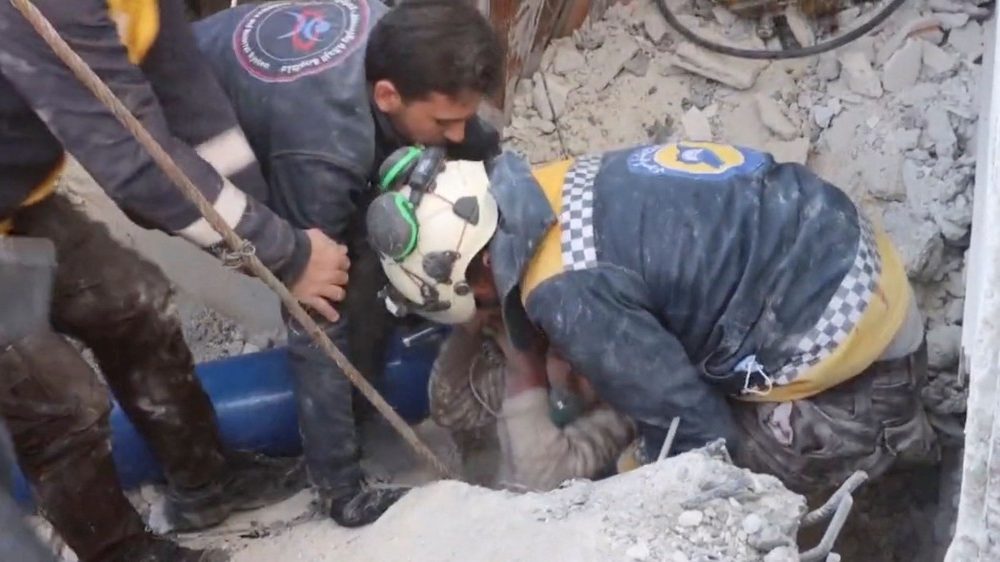 Os voluntrios do Capacete Branco retiram uma crian?a dos escombros enquanto a resgatam, aps um terremoto mortal, em Jandaris, , em 8 de fevereiro de 2023, nesta imagem esttica obtida de um vdeo de mdia social. Os Capacetes Brancos/via REUTERS