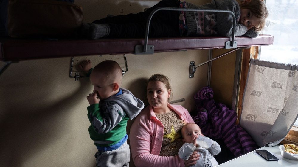 Iryna Hryhorieva senta-se com seus filhos, Violetta, 6, Bohdan, 2, e Karolina, que tem seis meses, dentro de um trem de evacua??o, depois de deixar sua aldeia de Min'kivka, localizada perto da linha de frente de Bakhmut, em meio  invas?o da Rssia. ataque  Ucr?nia, na esta??o ferroviria de Pokrovsk, regi?o de Donetsk, Ucr?nia, 13 de fevereiro de 2023. REUTERS/Marko Djurica