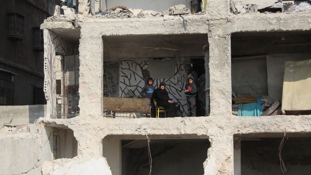 A sria Amina Raslan senta-se com seu filho e netos, na casa parcialmente danificada de seu filho, aps um terremoto mortal, em Aleppo, , 13 de fevereiro de 2023. REUTERS/Firas Makdesi