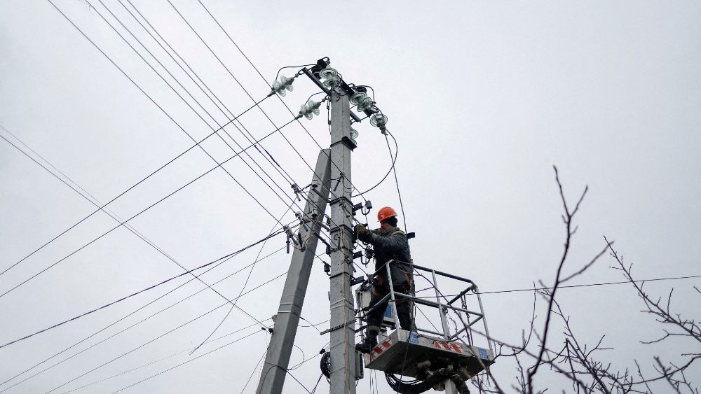 Funcionrio de fornecedor de energia conserta linhas de energia em frente a residncias danificadas por um ataque militar russo, em meio ao ataque da Rssia  Ucr?nia, na cidade de Hlevakha, nos arredores de Kiev, Ucr?nia, 26 de janeiro de 2023. REUTERS/Valentyn Ogirenko/Foto de arquivo