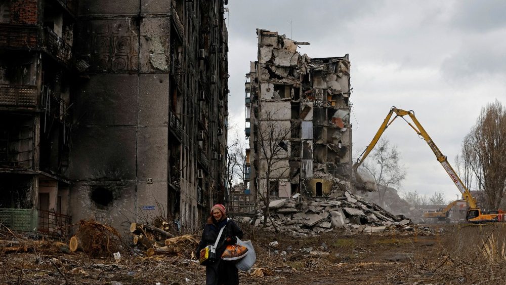 Ucraniana caminha desolada em meio a prdios de apartamentos em runas em Mariupol. REUTERS/Alexander Ermochenko