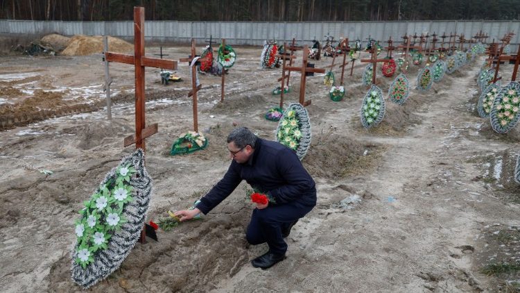 Varias personas visitan las tumbas de personas no identificadas, en un da del primer aniversario del ataque de Rusia a Ucrania, en Bucha.