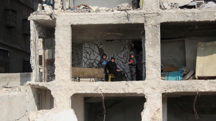 Una familia en una casa da?ada en Alepo 