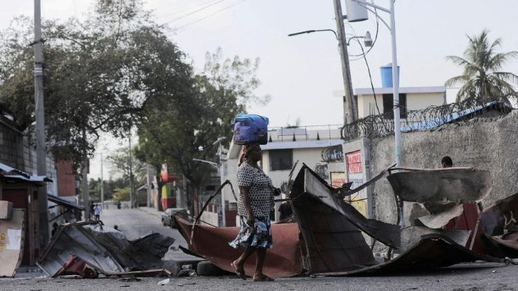 Une femme marchant devant une barricade au milieu de la violence des gangs à Port-au-Prince, Haïti, le 3 mars 2023. 