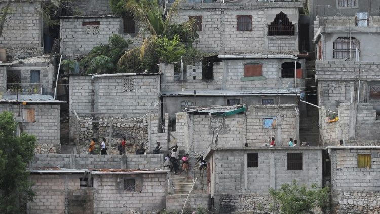 People carry their belongings in a Port-au-Prince neighbourhood as they flee their homes due to clashes between gangs