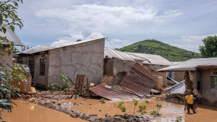 A boy wades through waters after his home was swamped, following rains that triggered flooding and landslides in Rwanda's Rubavu district